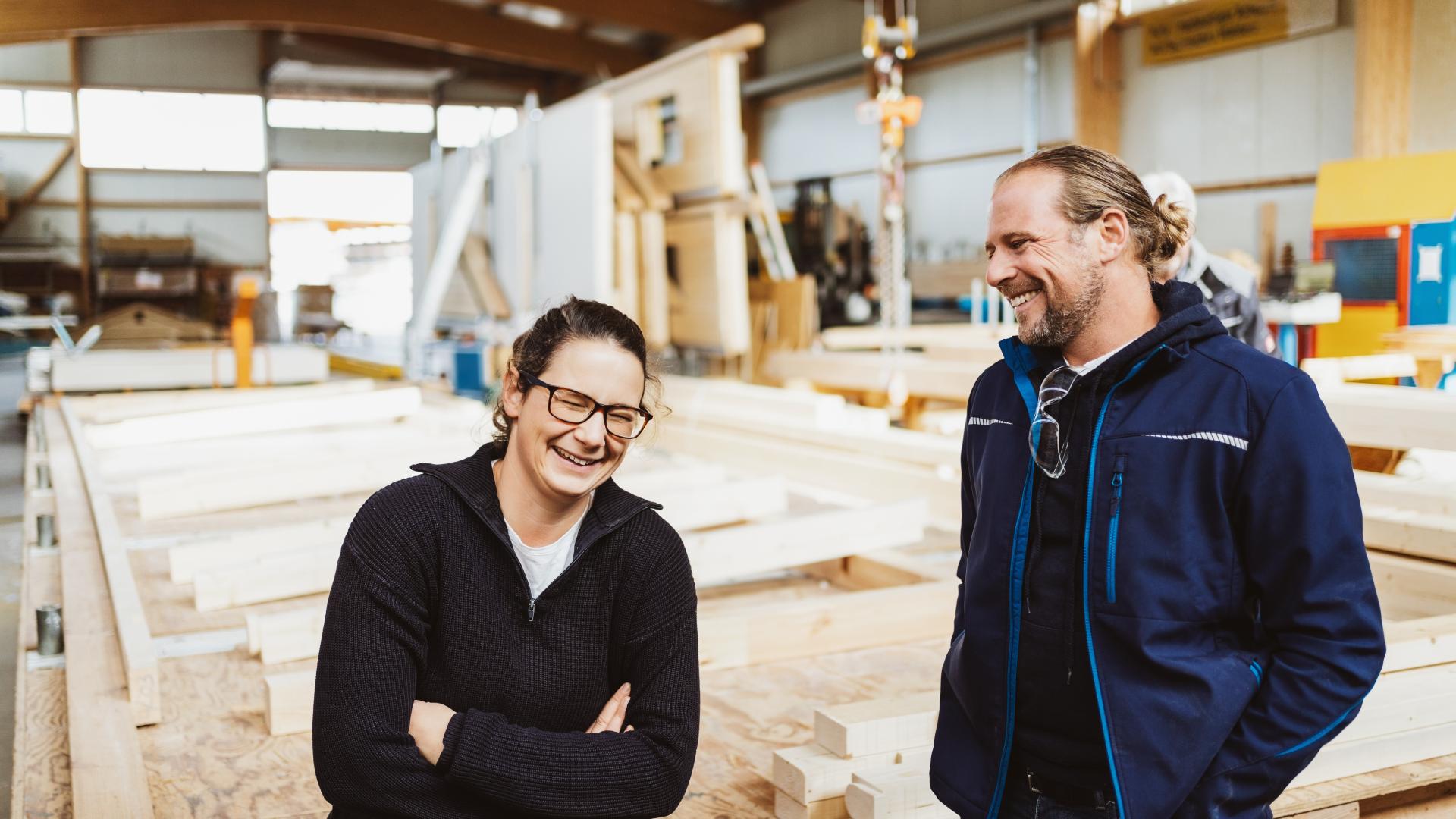 To fornoyde handverkere smiler til hverandre