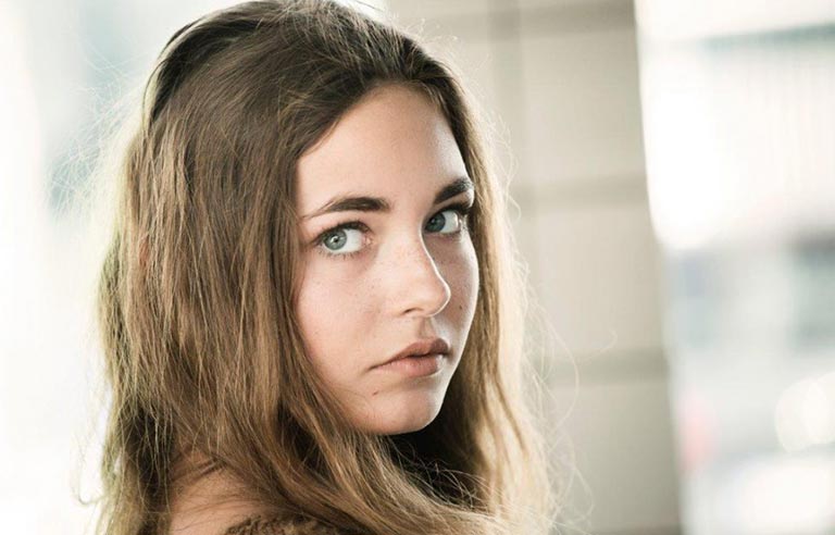 Nærbilde av en ung jente med et alvorlig blikk.