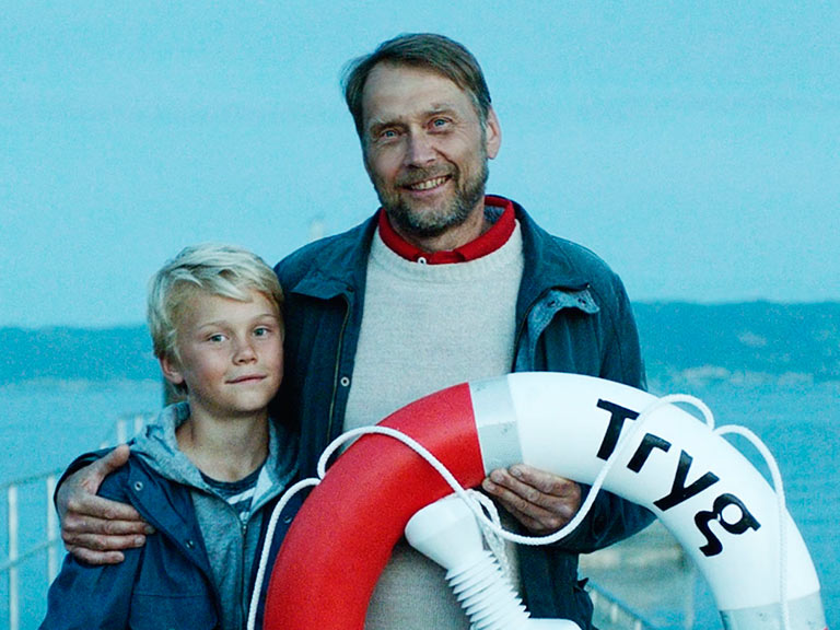 Øyvind og Eirik holder en Tryg-livbøye