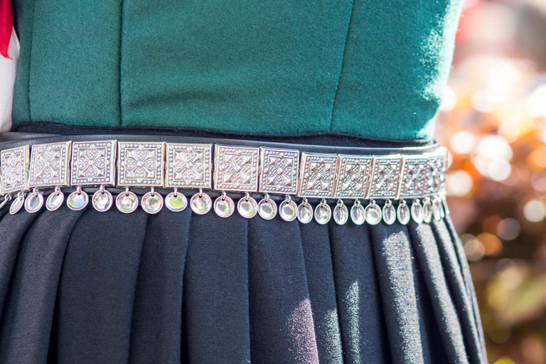 Bilde av midjen til en dame iført bunad med konebelte i sølv.