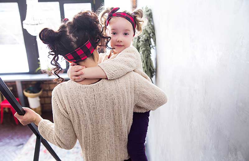 Mor bærer barn ned trapp, mens de utfører brannøvelse