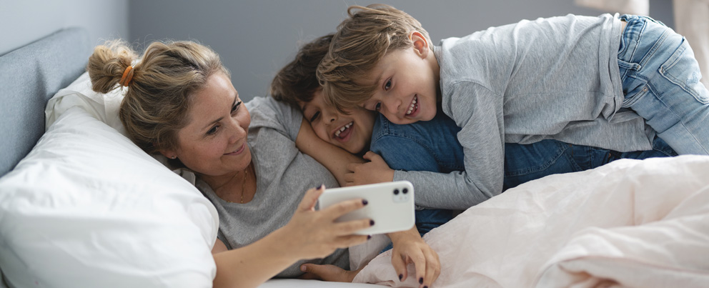 Mor med barn ser på mobilen