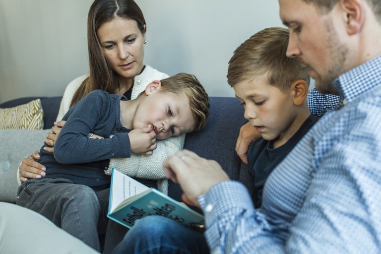 En familie som sitter i en sofa