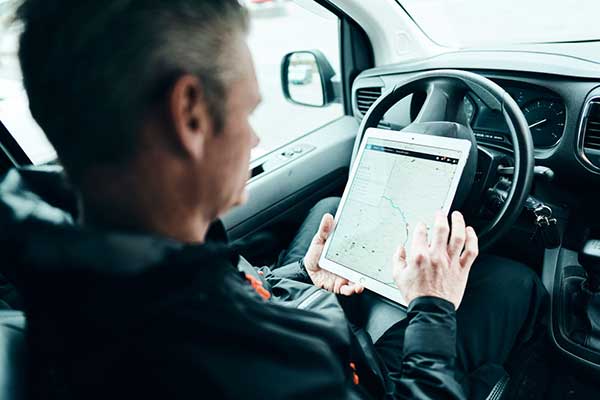 Mann bruker Abax app på nettbrett i firmabilen