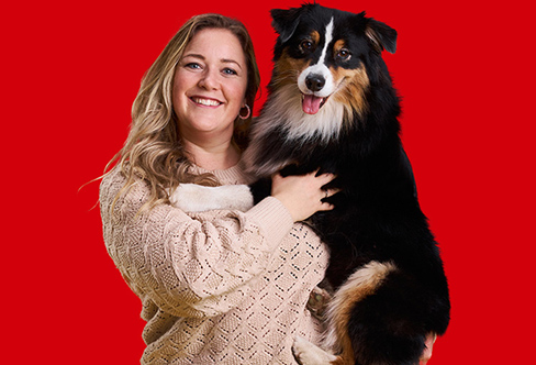 Hundetreneren Maren Teien Rørvik holder en sort hund