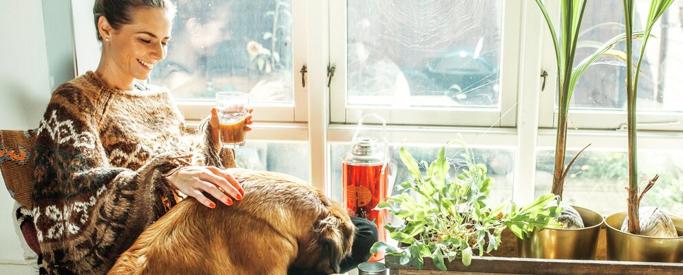Kvinne sitter i vinduskarm sammen med hunden sin
