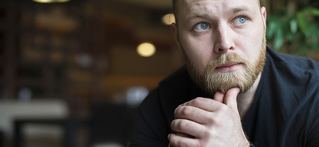 Mann sitter og tenker