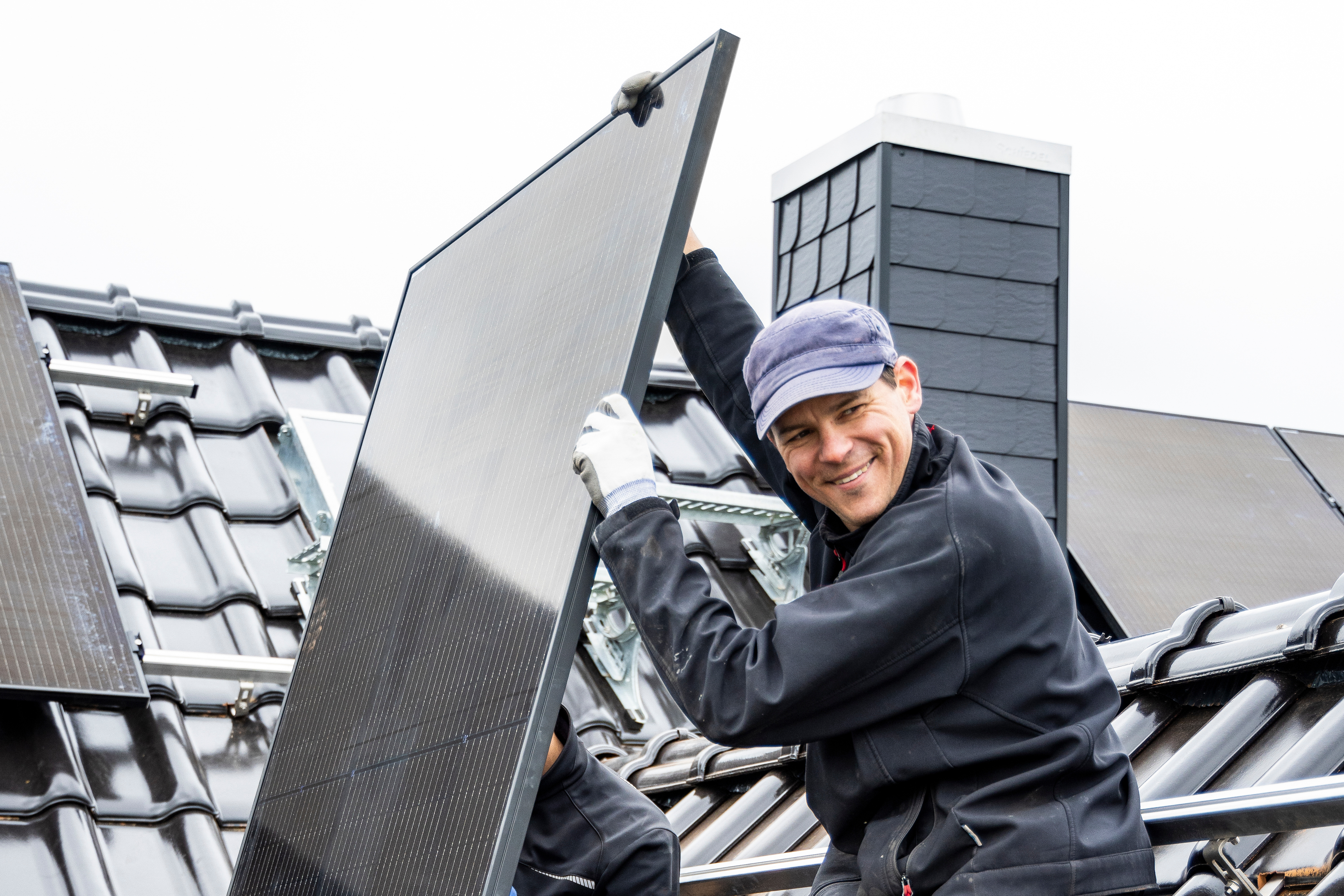 Elektriker installerer solceller på et hustak