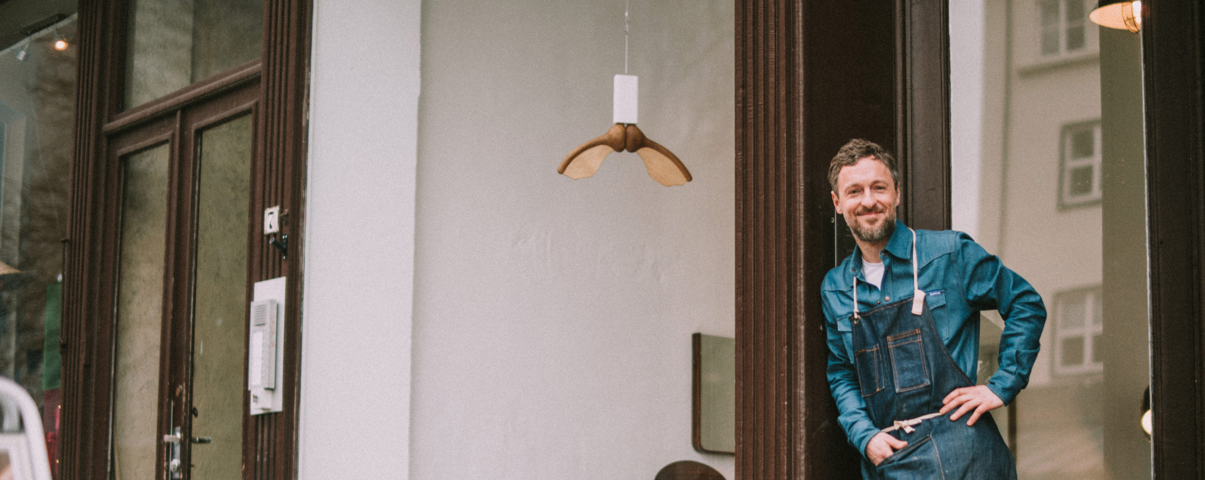 Smilende mann utenfor butikk