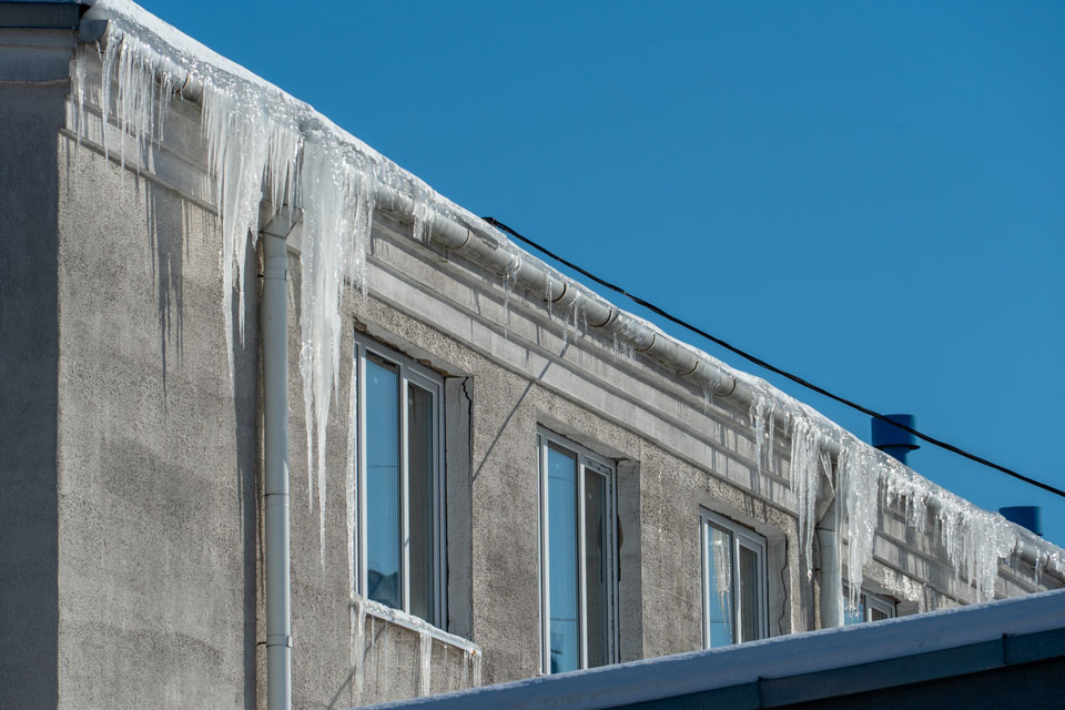 Istapper som henger ned fra et industribygg