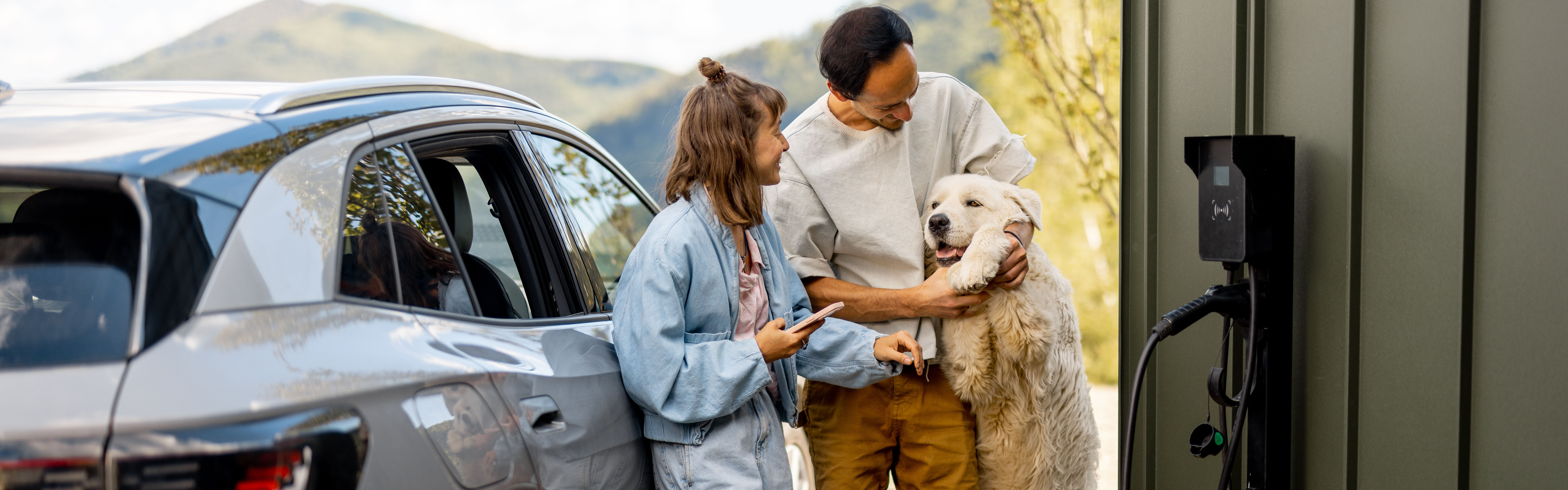 Familie med hund som lader bilen