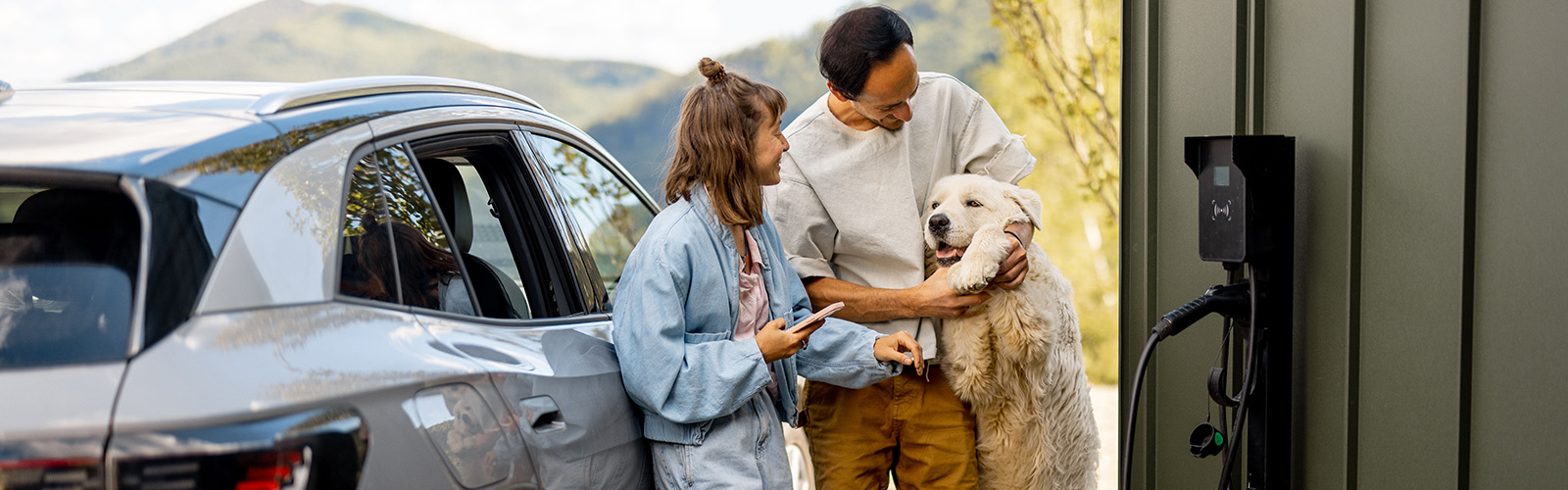 Familie med hund som lader bilen