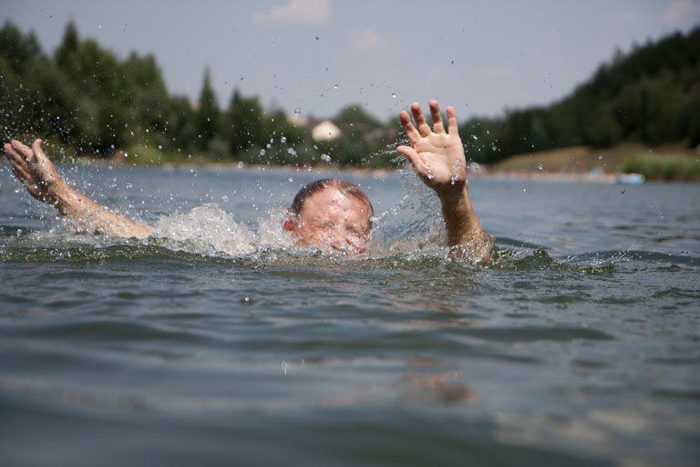 En person holder på å drukne og veiver med armene