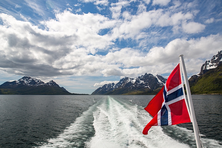 Aktersjøen på en båt i fart og norsk flagg - gode råd om sesongstart for båteiere