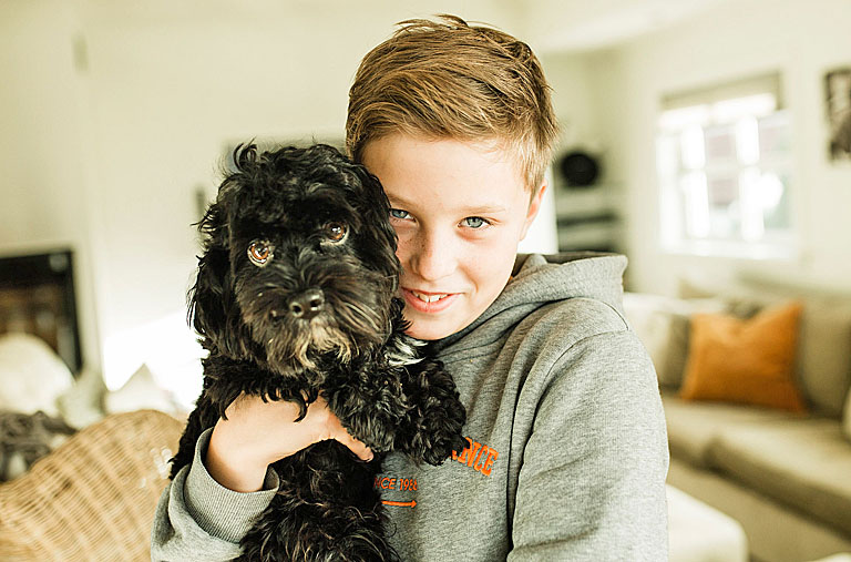 Ung gutt holder sin svarte, lille hund