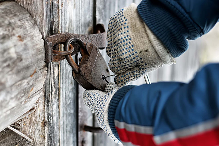 Hanskekledde hender dirker en hengelås