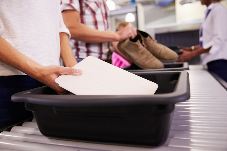 Plastkasser med eiendeler i sikkerhetskontrollen på flyplassen