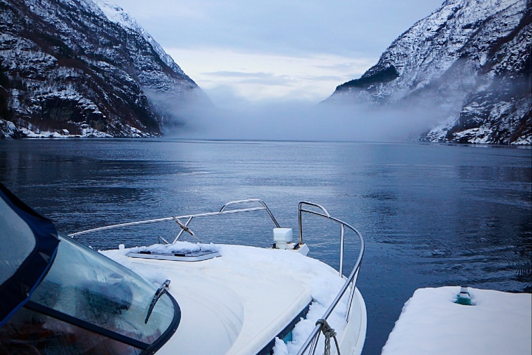Båt ved en kai i en fjord om vinteren