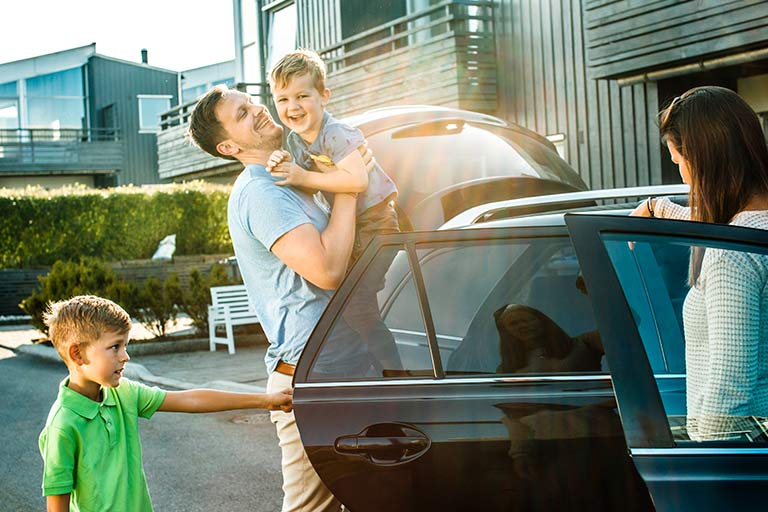 Familie på vei ut av bilen utenfor huset sitt