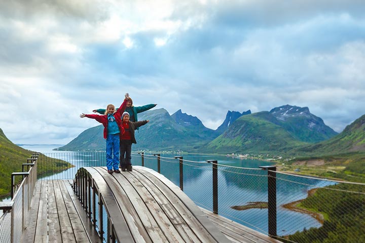 Reiseforsikring - familie på tur med hav og fjell i bakgrunnen