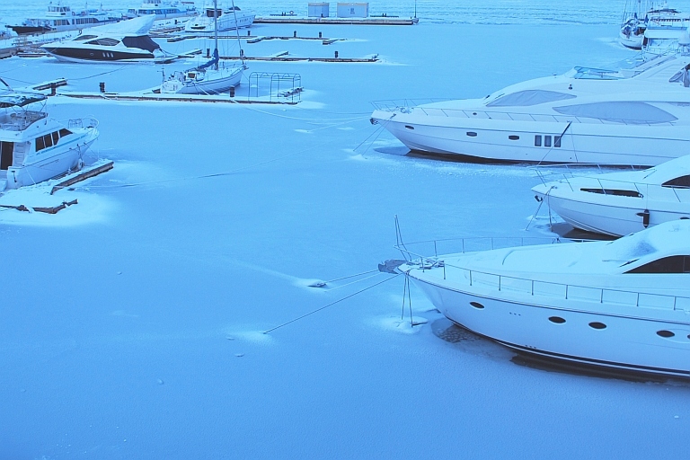 Marina med båter dekket av snø