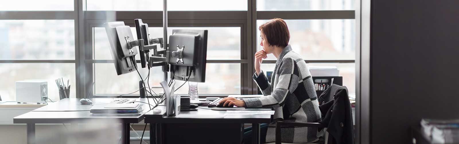 Kvinne jobber på pc på kontor